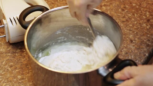 Pouring boiling water into a saucepan and mixing with flour and raw eggs