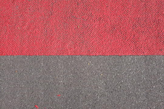 Graphic abstract Close up of grey Pavement with red painted Area, Road Construction or bike Path in europe