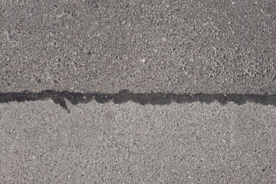 Close up of rough grey asphalt road or bike path, grungy graphic background