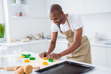Portrait of his he nice attractive cheerful cheery focused guy making handmade pie cake using form shape holiday day easter having fun in modern light white interior house kitchen