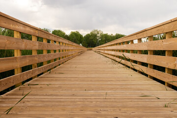 Wooden bridge over a small fishing lake. 