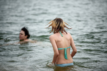 Two girls swim in the lake in the summer. The concept of a summer vacation.