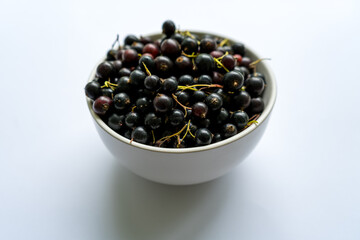 Fresh ripe berries black currants in a white plate 