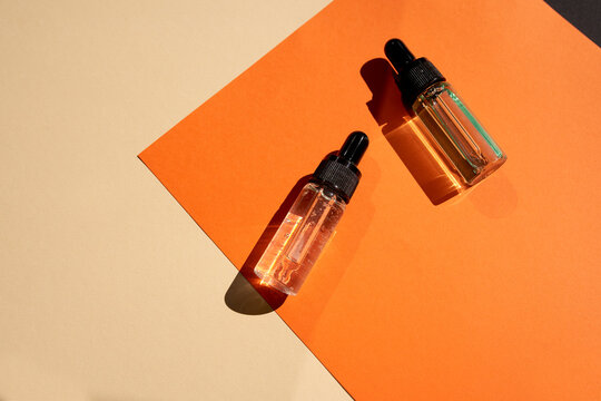 Essential oils on the trendy geometric background with shadows. Modern beauty product