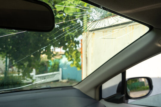 Broken Windshield With A Lot Of Cracks And Small Glass Pieces, Damaged Car