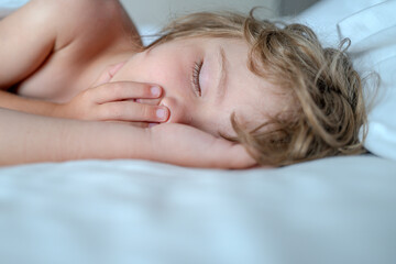Little kids sleeping with her mouth open, snoring. Kid in bedroom sleep on bed with white sheet and...