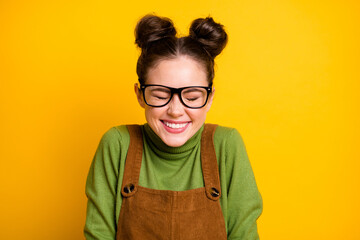 Closeup photo of attractive crazy lady two funny buns good mood high school student giggling overjoyed wear specs green pullover brown overall isolated bright yellow color background