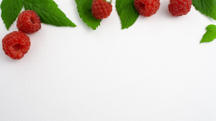Concept ripe raspberries isolated on white background close-up. Beautiful red fresh raspberries with leaves along the contour on the table. Top view. Banner for the site. Free space for text