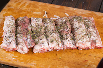 Preparation and cooking of pork ribs by a chef for a grill.