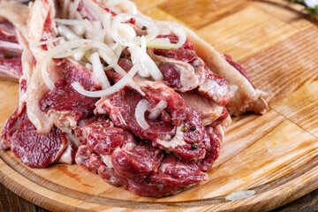 Raw fresh beef rib eye steak and seasoning on wooden background