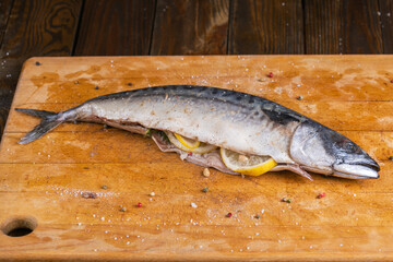 Raw mackerel stuffed lemon on wooden board