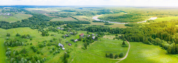 Aerial view from a drone of a rural village in the Kostroma region, fields and forests around.