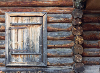 A fragment of an old wooden hut with a door. An old wooden door for entering and exiting the house