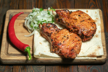 Pork steak with pepper on wooden board