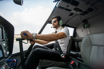 Confident pilot. Confident male pilot in uniform in control room cockpit and smiling with airplane...