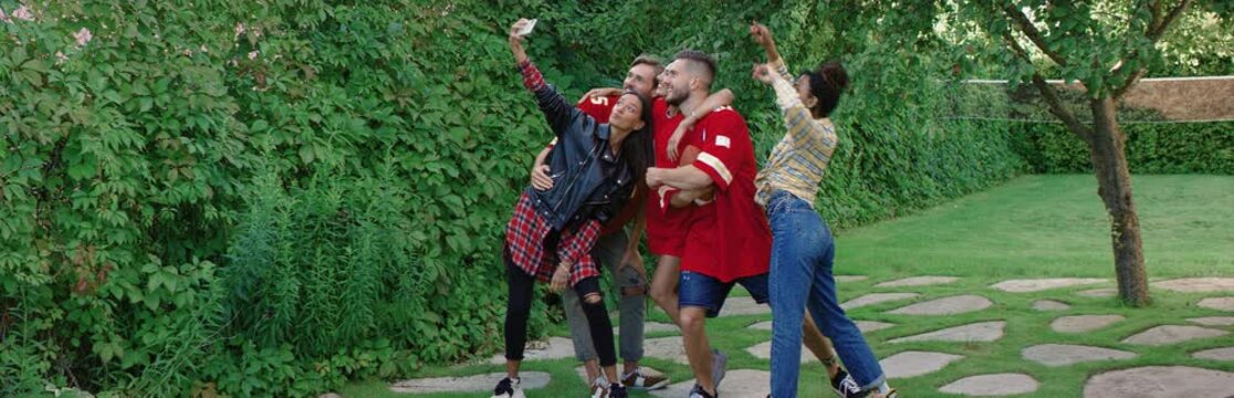 Diverse group of college friends making a selfie during outdoor party. Spring break, college life. Shot on RED cinema camera with 2x Anamorphic lens