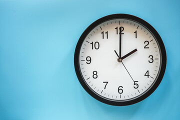 Obraz na płótnie Canvas Classic black and white analog clock on blue background at Two o'clock with copy space