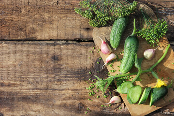 Fresh vegetables. Cucumbers, garlic, herbs, dill on an old wooden background. Agricultures. Flatlay. Rustic. Background image, copy space