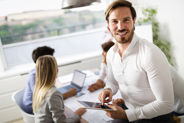 Portrait of young businessman with digital tablet in office