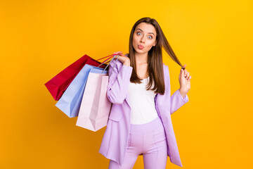 Portrait of her she nice-looking pretty attractive lovely charming cheerful cheery funky childish girl carrying bags grimacing pout lips isolated on bright vivid shine vibrant yellow color background