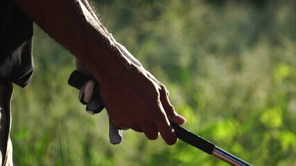 Footage Slow Motion: Man's hand holding a golf club with a warm light at sunset