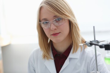 Smiling beautiful technician woman portrait and sample bottle with poison fluid. Medical worker in...