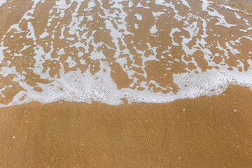 Sandy beach with waves. Empty sea and beach background with copy space