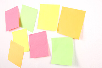group of blank colorful paper sticky notes isolated on white wall with copy space for your text