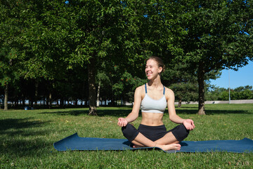 Young slim girl doing yoga, lotus position, relaxation and meditation