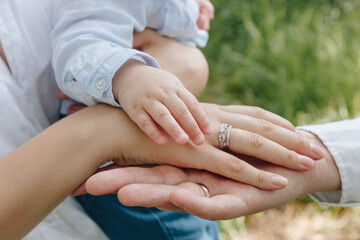 Hands of father, mother and kid