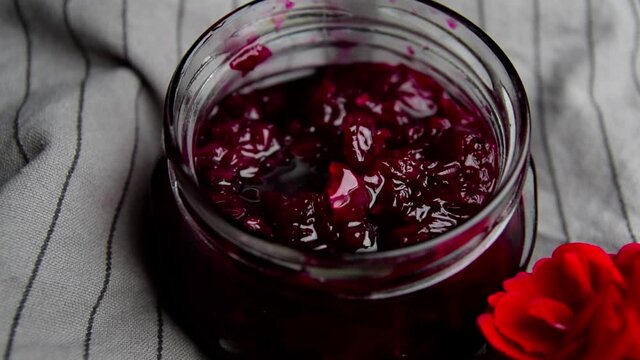 Homemade jam from rose petals in a jar on a dark background