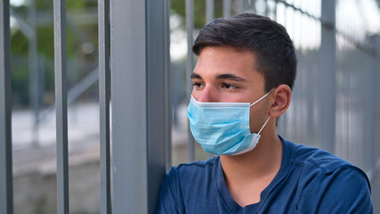 Young teen boy wearing face mask outdoor due to the Coronavirus Pandemic