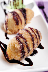 A Dish Of Fried Banana With Chocolate Sauce