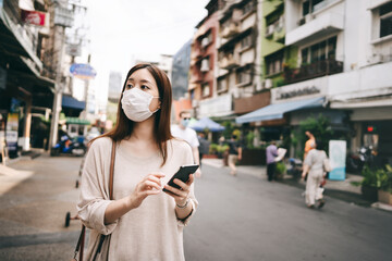 Fototapeta premium Business young asian single woman wear mask for corona virus or covid19 at city outdoor
