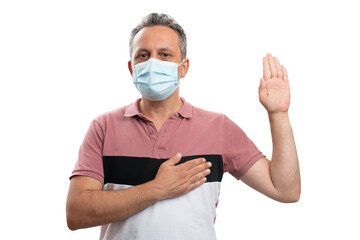 Oath or vow gesture made by man wearing medical mask