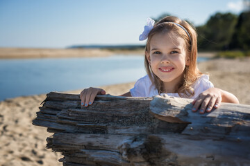 A little girl enjoys the sunny warm day at the sandy beach
