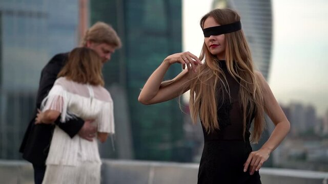 woman is dancing with closed eyes and man is dancing with other woman, love of three people