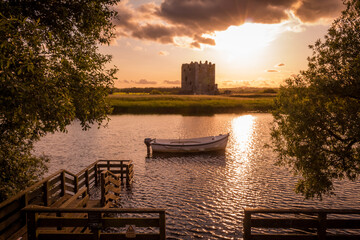 The evening sun behind Threave Castle at the boat jetty on the River Dee