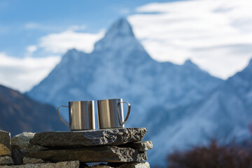 Everest Base Camp trekking. Two cups of tea on the background of Mount Ama Dablam in focus....