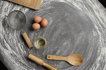 Chicken egg, flour, olive oil, kitchen tool on gray table background. Products