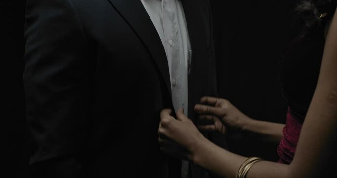 Beautiful woman is adjusting the suit of a man, elegant couple, 4k