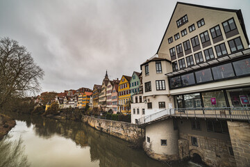 Obraz premium Medieval German houses reflecting on the River Neckar 's water with (Stiftskirche St Georg) Saint George Church bell tower sticking out of the pitched roofs - Tübingen, Germany