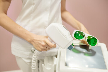 The nurse performs the manipulations with the lymphatic drainage apparatus on the woman's abdomen,...