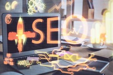 Multi exposure of table with computer and seo drawing hologram. Search optimization concept.