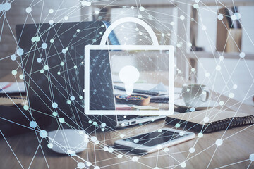 Double exposure of desktop with computer and lock icon hologram. Concept of data safety.