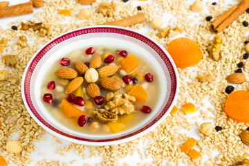 Traditional Turkish Dessert Ashure or Noah's Pudding in white bowl on ingredients of Ashure Dessert