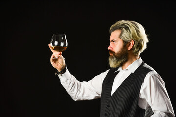 tasting sediments. Wine tasting. Male skilled sommelier estimates alcoholic drink. red wine in long-stemmed wineglasses. bearded man taste wine in restaurant. Checking color and sediments of wine