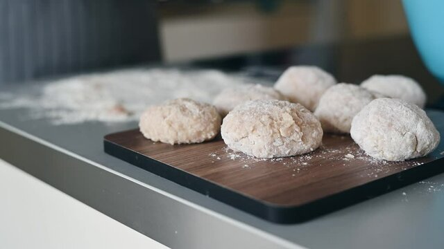 Close-up of a tasty cutlets, a female cook cooks meatballs, dipping cutlets of minced meat in flour and spreading it on a baking tray.