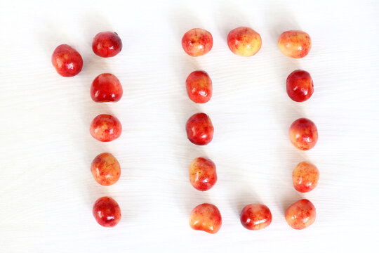 Number Ten From Berries Of Sweet Cherry On A Light Surface Top View. Sweet Countdown 10