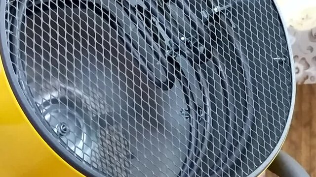 Winter cold. Operation of the heater. room heating in winter.Heat gun at work in the building. He warms his hands in a stream of hot air.